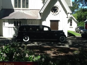 Cool hearse in front of church.